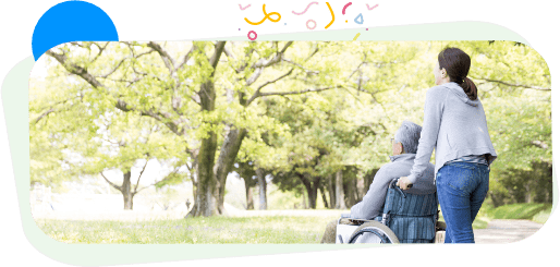 elderly person being wheeled through a park